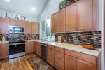 Kitchen features a glass top stove and stainless steel appliances